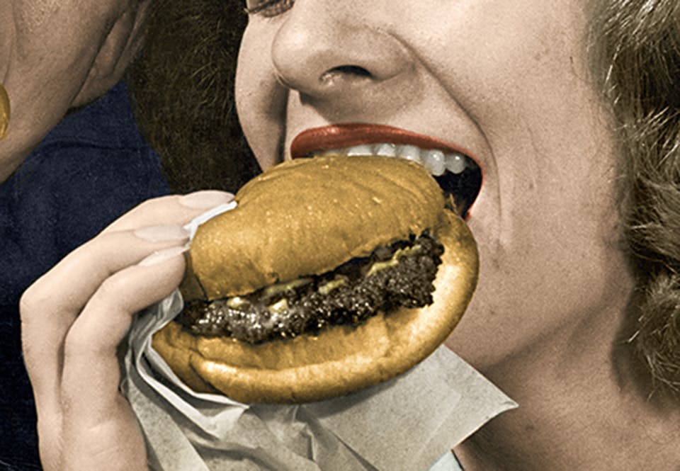 hamburgare snabbmat historia2 Kvinna som äter en hamburgare.